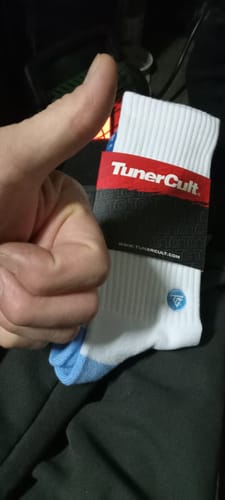Reviewer giving a thumbs-up while holding new white MOONSTONE CREW SOCKS with a blue toe.