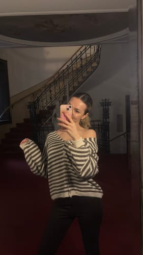 Rezensentin trägt den gestreiften Cardigan lässig über eine Schulter fallend in einer Spiegelaufnahme.