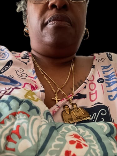 Customer displays their gold-tone necklace with a custom engraved photo pendant.
