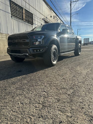 Customer's gray Ford Raptor truck parked on a gravel lot before installing the Rear Traction Bar Kit.