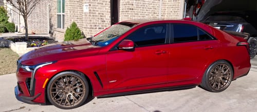 Reviewer's shiny red sedan parked in a driveway, showing a spotless finish after being dried.