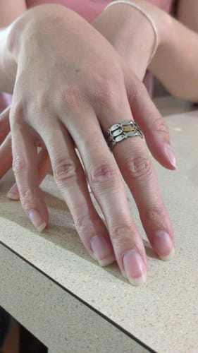 Reviewer wearing the Just Keep Swimming Ring, a silver band with a pattern of fish and one contrasting gold fish.