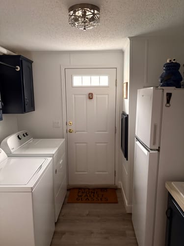 Reviewer's white door with the Clear 4 Lite Glass and Frame Kit installed in a well-lit laundry room.