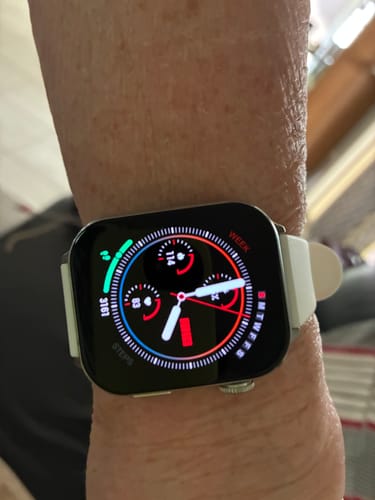 Customer wearing a smartwatch with a white band, showing a colorful digital face with health metrics.