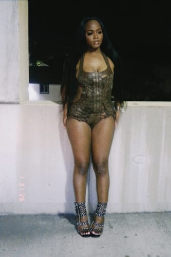 Customer standing at night wearing the brown, textured Vice Body bodysuit.