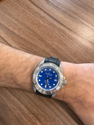 Customer wearing their Oceaneva Damascus Steel Watch, showing the bright blue dial and black strap on their wrist.