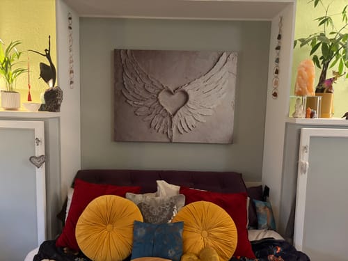 Customer's Angel Wings Wall Art with a stunning 3D effect, hanging above a bed in a living space.