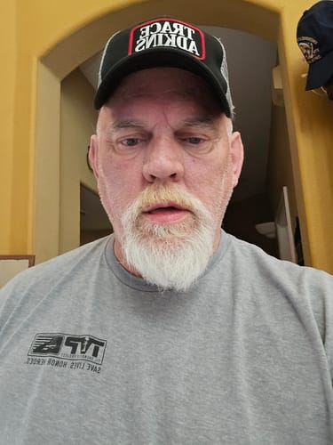 Customer wearing a grey t-shirt with the T.V.P. logo from the Elite Membership.