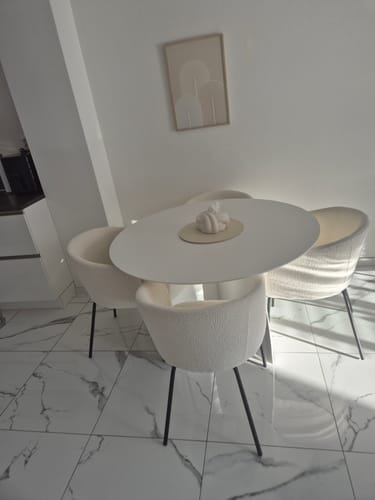 Klant toont de witte Noux Eettafel, omringd door vier stoelen op een marmeren vloer.