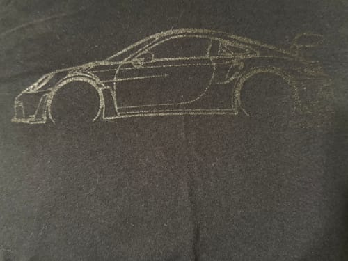 Reviewer's close-up of the DCG #85 Shirt, showing the subtle black-on-black car graphic.