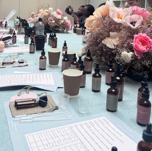 Customer's view of the Perfume Making Workshop, showing a table set with essential oils, notes, and blending equipment.
