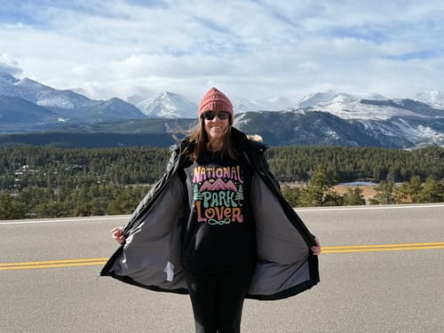 Reviewer showing off their black National Park Lover sweatshirt outdoors with a scenic mountain view.