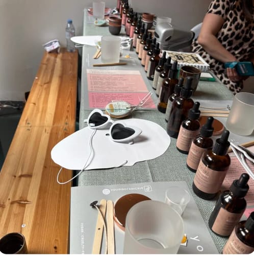 Reviewer's table at the candle making workshop, set with rows of essential oils and supplies for the class.