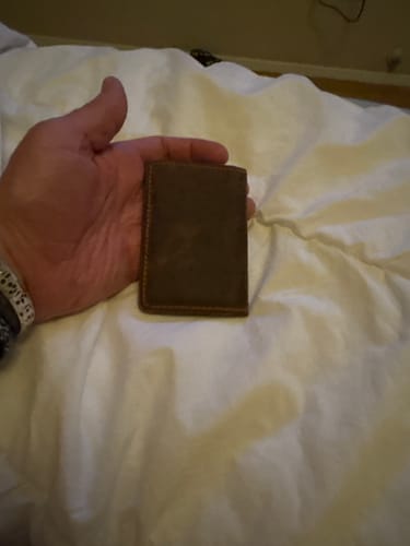 Customer holding the compact brown Tupper Bifold Card Holder in their hand.