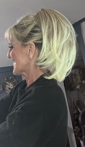 Side view of a reviewer wearing the voluminous, layered JuvaBun Claw Clip Straight Ponytail Extension.
