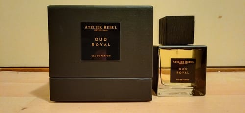 Recensent toont het flesje Oud Royal Herenparfum naast de donkere doos op een houten oppervlak.