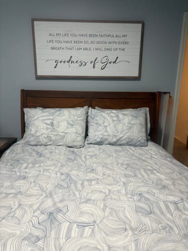Customer's framed Goodness Of God Faith Sign hanging on a bedroom wall above a bed.