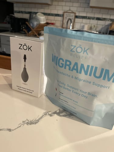 Customer's pouch of Migranium sitting on a kitchen counter next to another Zōk relief product.