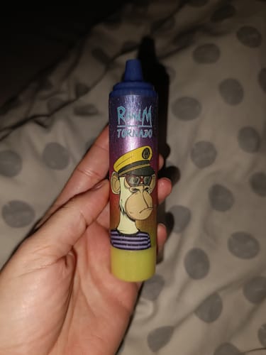 Ein Kunde hält den RANDM TORNADO 15000 Vape mit einer bunten Affen-Grafik in der Hand.