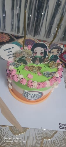 Customer's Demon Slayers Cake decorated with character cutouts, the show's logo, and pink and white floral frosting.