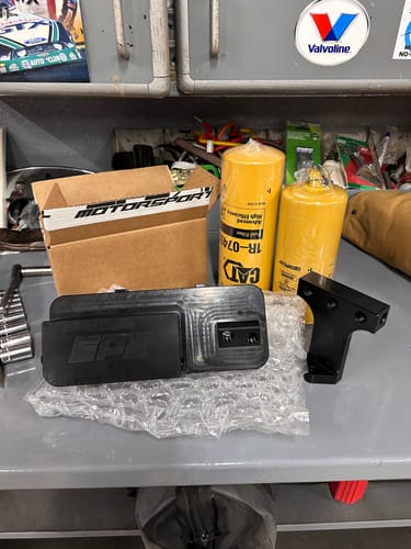 Customer's SPE Motorsport fuel filter system components, including two yellow CAT filters, displayed on a workbench.