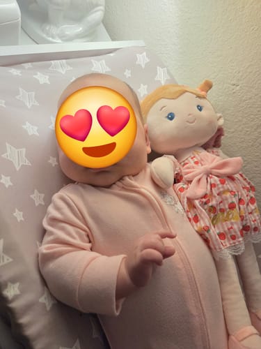 Customer's adorable Personalized Strawberry Girl soft doll lying next to a baby.