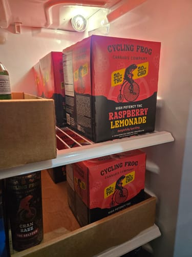 Reviewer's refrigerator stocked with multiple red boxes of Sparkling THC Raspberry Lemonade.