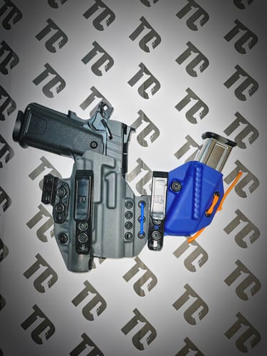 Customer's grey XIPHOS ELITE holster holding a black handgun, shown with a blue magazine holster.