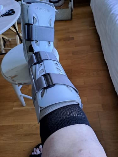 Kundens svarta Diasocks Komfortstrumpor som bärs bekvämt inuti en grå walkerortos.