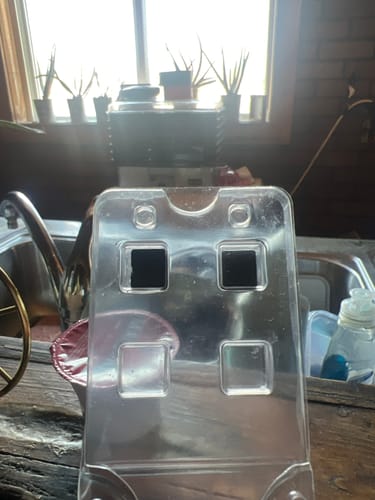 Customer holding the clear packaging for Just Blue™ with two troches remaining.