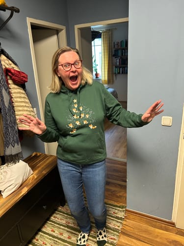 Eine Kundin präsentiert begeistert ihren grünen Foxy Xmas Hoodie.