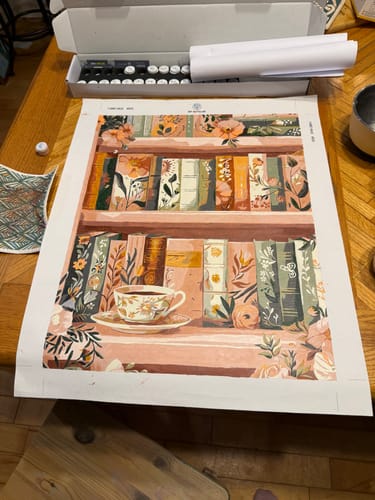 Customer's beautifully finished 'Blooming library' paint-by-number canvas laid flat on a wooden table.