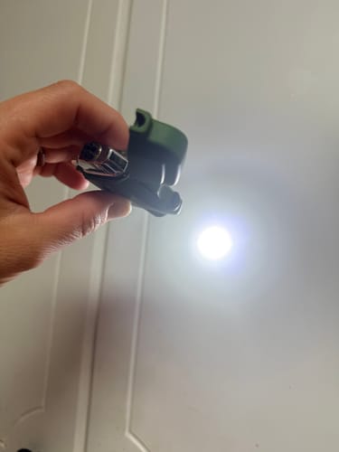 Customer holding the green Arc Lighter with its bright, powerful flashlight turned on.