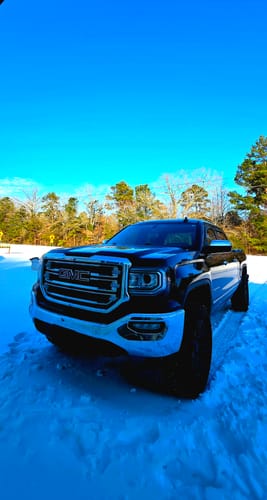 Customer's black GMC truck in the snow after installing the upper control arms.