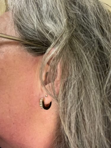 Close-up of a reviewer wearing the shiny Studded Hoop Earring.