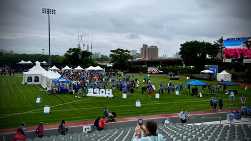 Customer's photo of a large outdoor charity event on a grassy field with many participants.