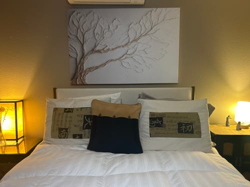 Customer's large Neutral Bedroom Wall Art with a textured branch design mounted on a wall above a bed.