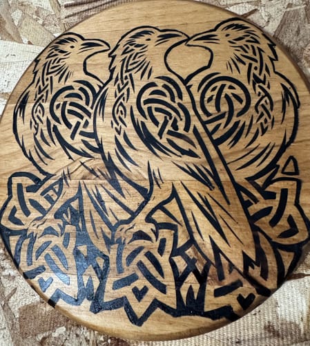 Customer's round wooden plaque with an intricate Celtic raven design created using Scorch Paint.