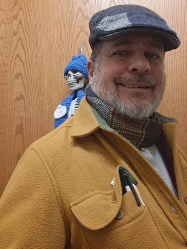 Customer smiling while wearing the multi-patterned Patchwork Tweed Scarf tucked under their jacket.