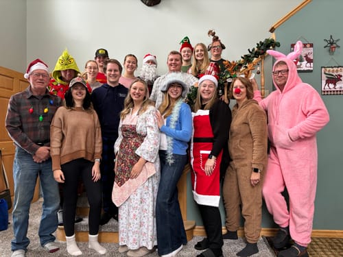 Reviewer and their large family posing in fun Christmas costumes while playing the murder mystery game.