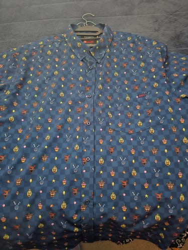 Customer's Five Nights at Freddy's "Pixel Peril" shirt on a hanger, showing the full pixelated character pattern against a dark background.