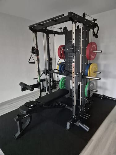 Kundenbild der fertig aufgebauten schwarzen SEK Multipresse mit Hantelbank und Gewichten in einem Raum.