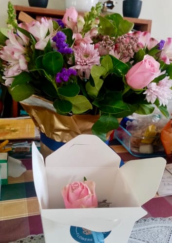 Customer's Harmony Flower Arrangement with lovely pink and purple flowers, next to a small box with a single rose.