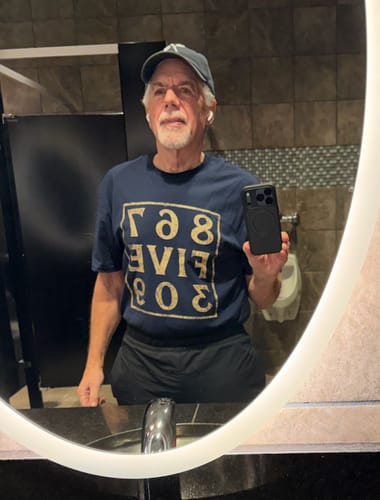 Reviewer wearing the dark blue 8675309 T-Shirt, taking a mirror selfie to show the fit.