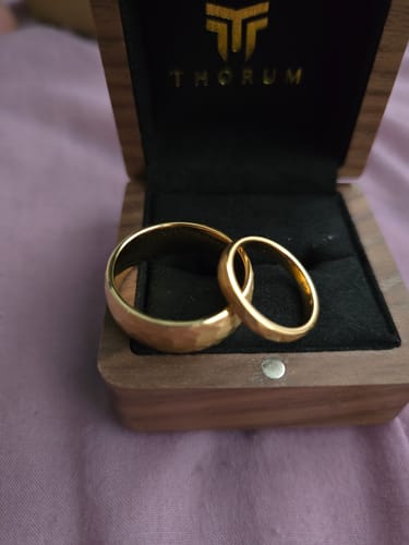 Customer's Thorum Freya Set, a pair of gold hammered rings, shown inside the open wooden box.