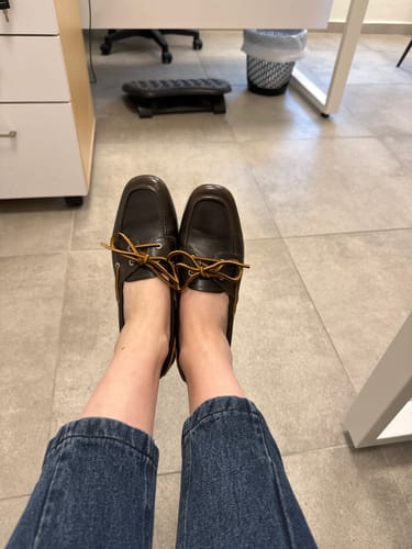 לקוחה מציגה את מוקסיני Hillary החומים שלה במשרד.