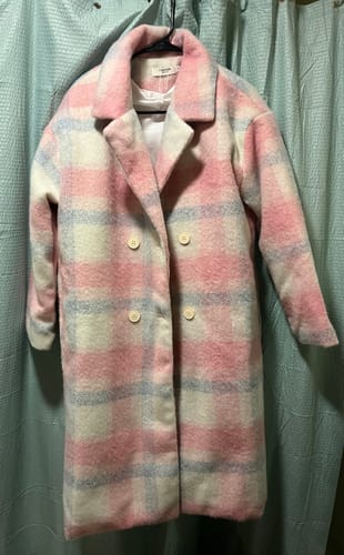 Reviewer's Nordic Women's Oversized Trench Coat in a pink plaid pattern hanging on a hanger.