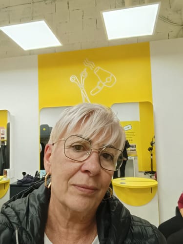 A reviewer with short blond hair and glasses in a salon. The FREE Shipping Protection product is not pictured.