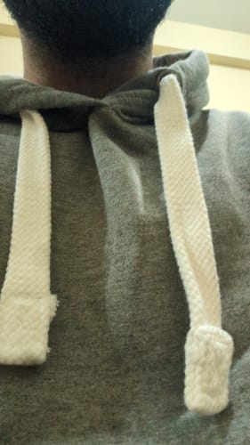 Close-up: Reviewer wearing the Grey Mist hoodie, showing the texture of the thick white rope drawstrings.