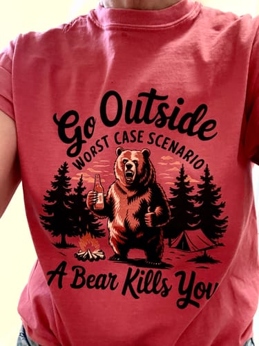 Reviewer wearing the red Go Outside T-shirt with its 'Worst Case Scenario' bear graphic.
